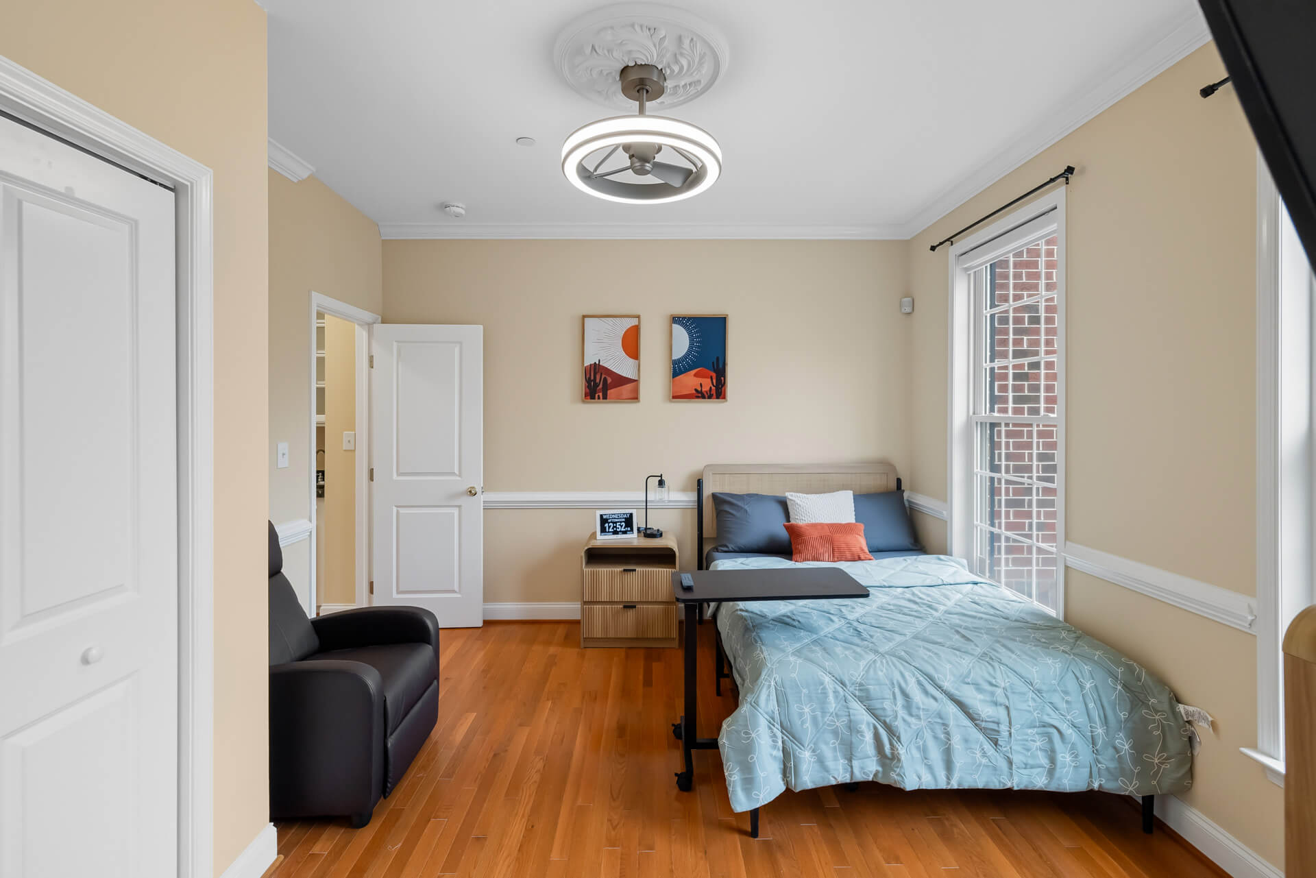Private resident bedroom with accessible clearances and warm lighting