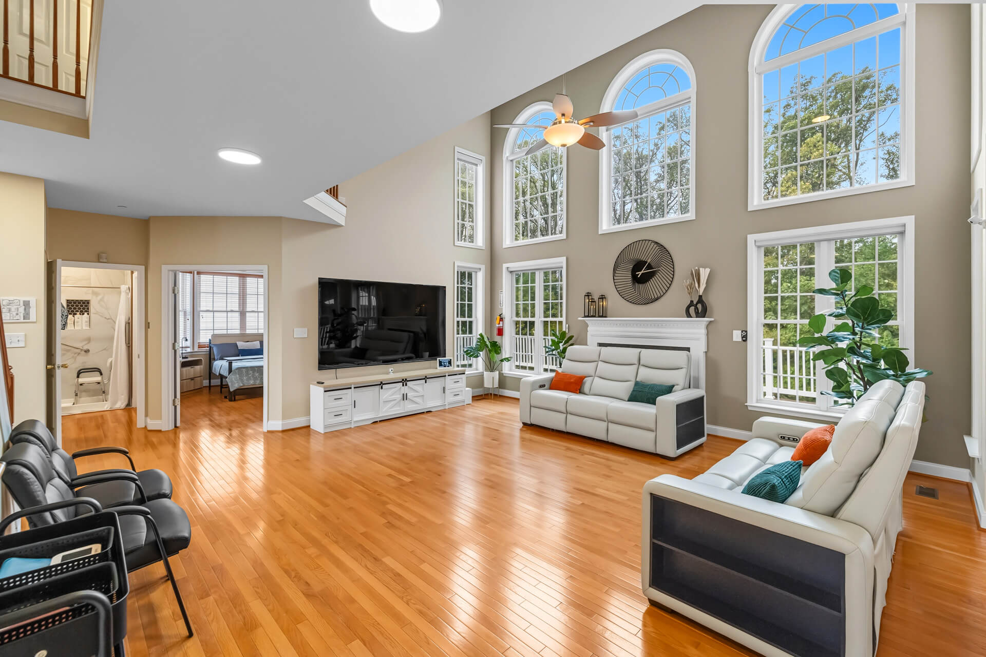 Cozy communal living room with multiple seating clusters and large windows